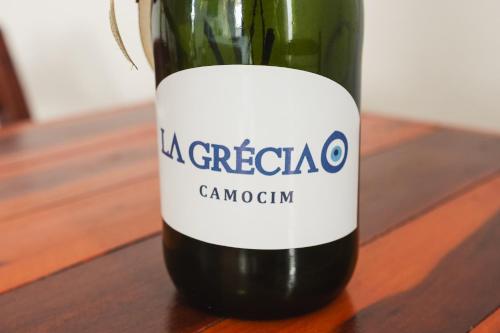 a bottle of wine sitting on a wooden table at Pousada La Grécia in Camocim