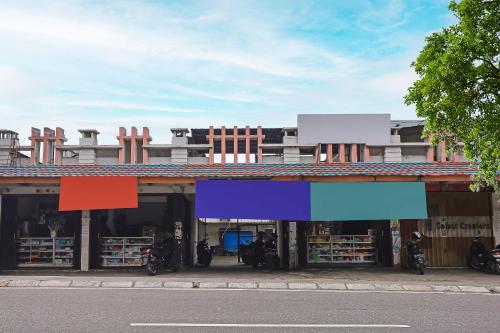a building with colorful signs on the front of it at Hotel O City Kost Syariah in Pangkalpinang