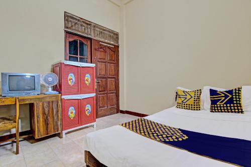 a room with two beds and a tv in it at Hotel O Puri Kasih Guest House Syariah in Solo