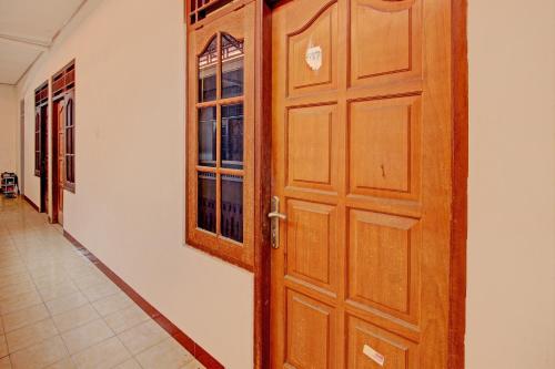 a wooden door in a room with a hallway at Hotel O Puri Kasih Guest House Syariah in Solo