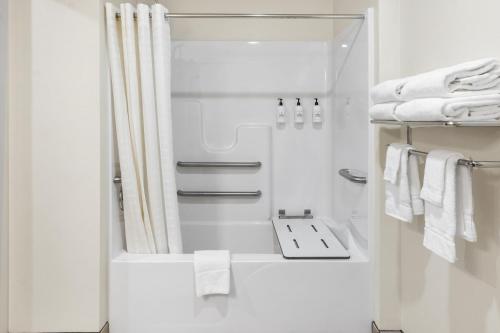 EatonCobblestone Hotel & Suites - Eaton的白色的浴室设有淋浴帘和毛巾。