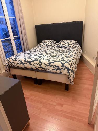 une chambre avec un lit avec une couette noire et blanche dans l'établissement Amazing 1 bedroom, 30sec from Arc de Triomphe, à Paris