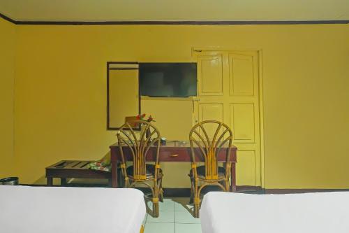 a dining room with a table and two chairs at Hotel O Azeela Kost Syariah in Banjarmasin
