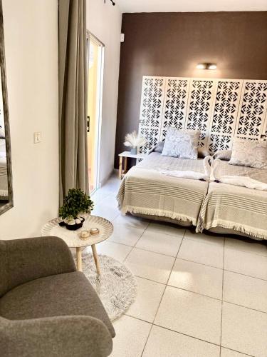 a bedroom with a bed and a chair and a couch at Gloria Suites at Pension Candelaria in Valle Gran Rey