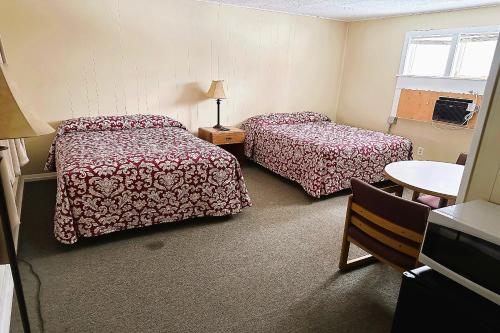 a hotel room with two beds and a table at Love Hotels Timberline By OYO Lake Superior in Ironwood