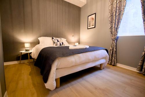 une chambre avec un lit avec deux lampes et une fenêtre dans l'établissement Hypercentre Cherbourg - Super appartement en RDC, intendance Luxury Host, à Cherbourg en Cotentin