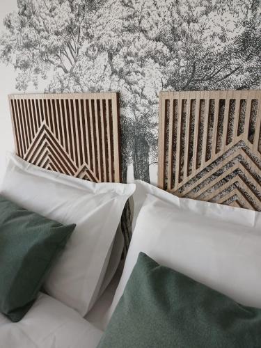 two wooden chairs with pillows in front of a wall at Gîte Héloïse in Le Pallet