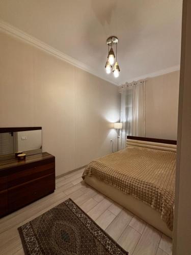 a bedroom with a bed and a dresser and a mirror at ELAY Apartments in Baku