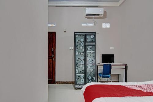 a bedroom with a bed and a desk with a computer at Hotel O Putri Homestay Syariah Near SPBU 14.282.694 (Air Hitam) in Pekanbaru