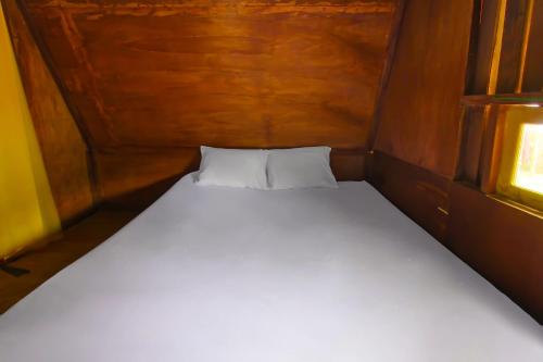 a bed in a small room with a window at Hotel O Awenk Homestay Near SD Gunung Wakul in Labuan Lombok