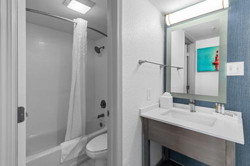 a bathroom with a sink and a toilet and a mirror at Compass Cove in Myrtle Beach