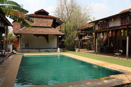 ein Swimmingpool vor einem Haus in der Unterkunft Capital O 75421 Baan Singkham Boutique Resort in Chiang Mai