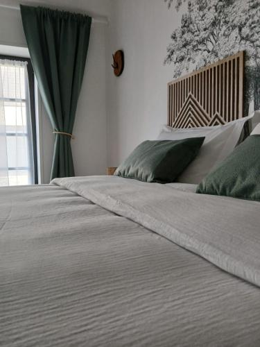 a bedroom with a large white bed with green pillows at Gîte Héloïse in Le Pallet