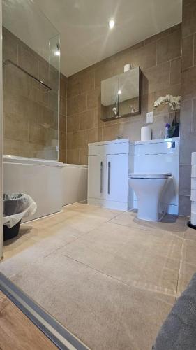 a bathroom with a toilet and a sink and a tub at The Retreat at Harlow in Potter Street
