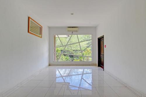 a room with a large window and a white wall at Collection O Gunung Kidul Near Pindul Cave Formerly Orchid Hotel in Duwet