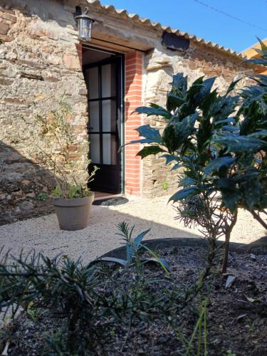 a house with a door and a plant in front of it at Gîte Héloïse in Le Pallet