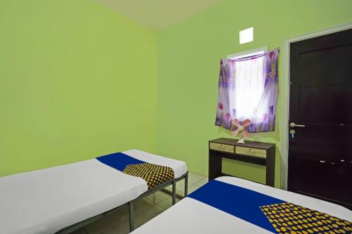 Кровать или кровати в номере OYO Life 92474 Penginapan Rusunawa Ii