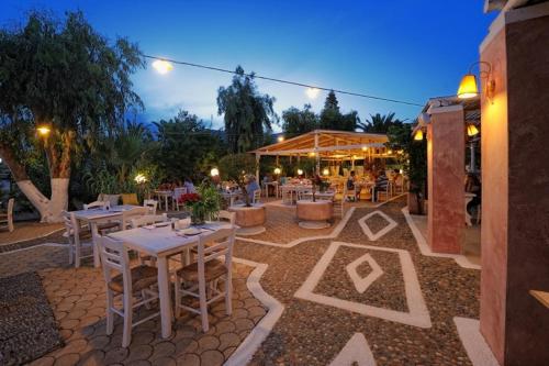 a patio with tables and chairs at a restaurant at Parthenis Hotel & Suites in Malia
