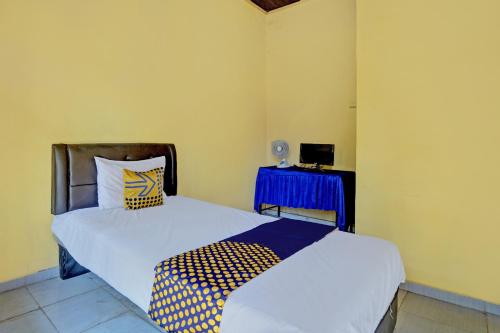a bedroom with two beds and a blue table at SPOT ON 92475 Rc Homestay Syariah in Banyuwangi