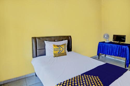 a bedroom with a bed and a blue table at SPOT ON 92475 Rc Homestay Syariah in Banyuwangi