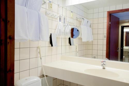 Baño blanco con lavabo y espejo en Torget Aparthotel en Pori