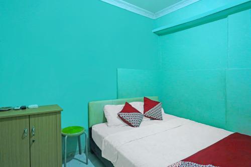 a bedroom with a bed and a blue wall at Hotel O Faraas Homestay Syariah in Nongsa