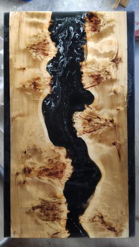 a wooden cutting board with black paint on it at Laska House in Pylypets