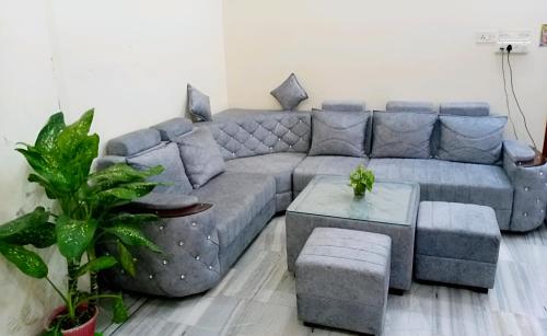 a living room with a gray couch and a table at Siddhivinayak Temple Guest House in Varanasi
