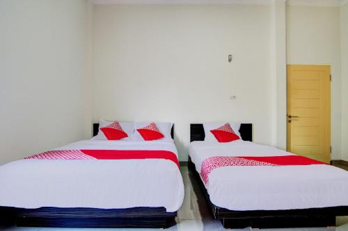 Postel nebo postele na pokoji v ubytování OYO 92497 Penginapan Pasir Indah SyariahNearMonument Park City Sand Pengaraian