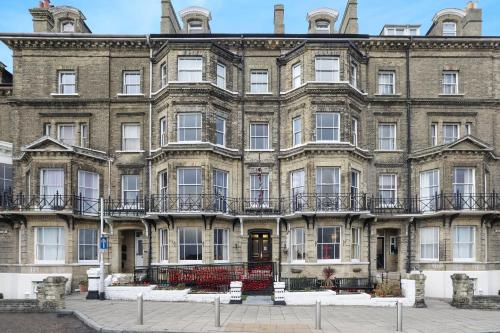 a large brick building with balconies on it at Lord Kitcheners Guest House in Lowestoft