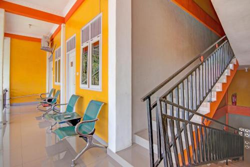a hallway with chairs and stairs in a building at Hotel O Wisma Sakinah Syariah in Rambah