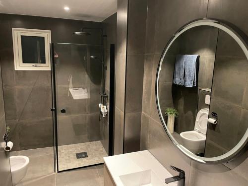 a bathroom with a shower and a sink and a mirror at Lars sitt hus in Lillehammer