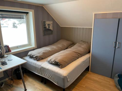a bedroom with a bed with two pillows on it at Lars sitt hus in Lillehammer