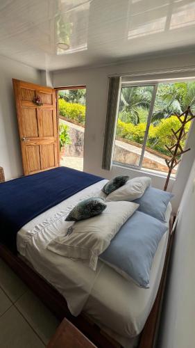 a bedroom with a bed with pillows and a window at Tambo Eco Hotel in La Vega
