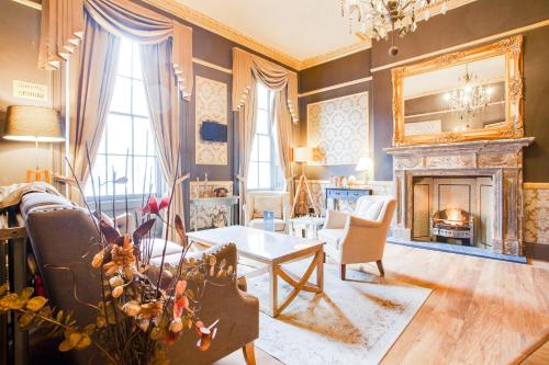 a living room with a fireplace and a table at The Somerset Baker Street London in London