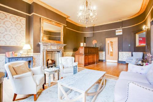 a living room with a table and chairs and a fireplace at The Somerset Baker Street London in London