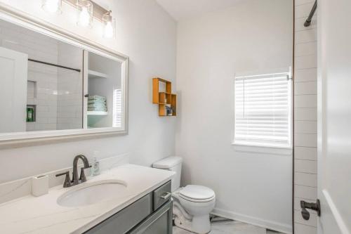 a white bathroom with a sink and a toilet at The Arches Walk To Western Ave District in Oklahoma City
