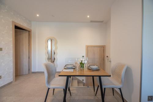 una sala da pranzo con tavolo e sedie in legno di NUBA apartamentos turísticos a Monforte de Lemos