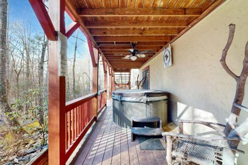 a porch with a bench and a ceiling fan at Moose Creek Lodge in Sylva