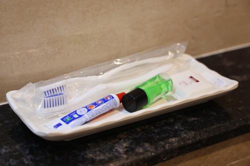a plastic container with a toothbrush and a tooth paste at Vibha by Sri Lakshmi Homes in Chennai
