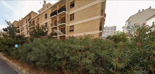 Un bâtiment avec une bande de buissons devant lui dans l'établissement Aix en Provence - Rotonde - Cours Mirabeau, à Aix-en-Provence