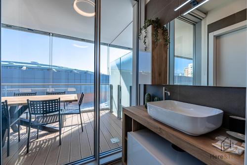 a bathroom with a tub and a table with a balcony at Luxury by the Sea - Free Park - Gym - UltraWiFi in Genova