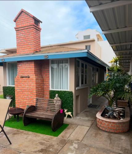 a brick house with a bench in front of it at Seaside Adventure Lodging in Ensenada