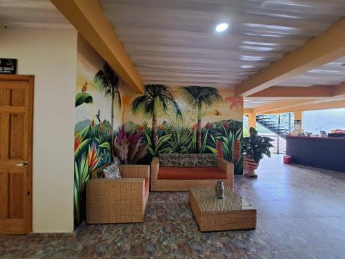 a lobby with a mural of palm trees on the wall at Tambo Eco Hotel in La Vega