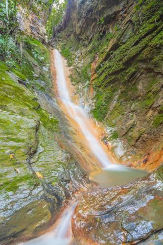 a waterfall on the side of a rocky mountain at Tambo Eco Hotel in La Vega