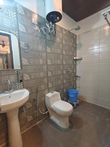a bathroom with a toilet and a sink and a mirror at Hotel Royal Plaza in Rishīkesh