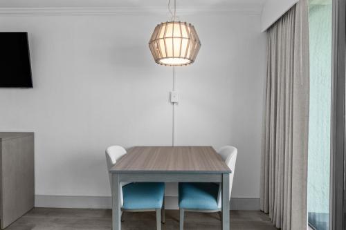 a dining room table with two chairs and a light fixture at Compass Cove in Myrtle Beach