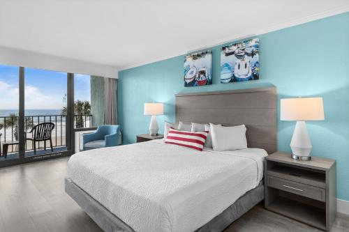 a bedroom with a large bed and a balcony at Compass Cove in Myrtle Beach