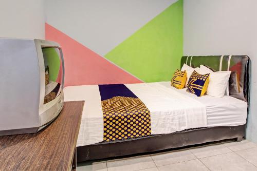 a bedroom with a bed with colorful walls at Hotel O Pacar Guesthouse in Pekalongan