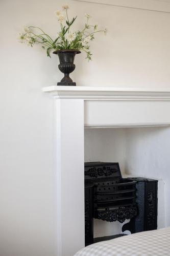 a vase with flowers sitting on top of a fireplace at Lawsons Estate on Macquarie Farm in Brewongle